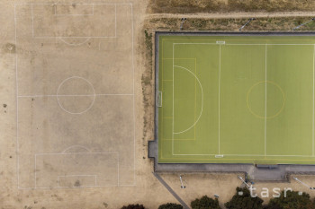 Na snímke vyprahnutá tráva obklopuje zelenú umelú trávu na futbalovom ihrisku v britskom Warwicku neďaleko Birminghamu 15. augusta 2022.