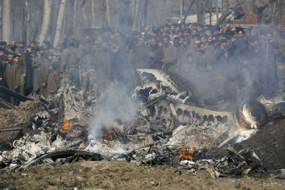 Kašmírski dedinčania sa zhromažďujú pri vraku indickej stíhačky po jej zostrelení pakistanskými silami v Budgame na predmestí Šrínagaru, v indickej časti Kašmíru 27. februára 2019. Foto: TASR/AP
