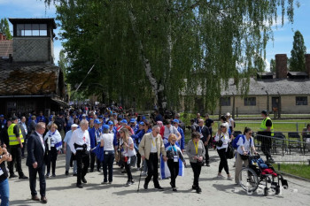 Ľudia kráčajú v bývalom nacistickom koncentračnom tábore Auschwitz-Birkenau počas Pochodu živých z Auschwitzu do Birkenau na pamiatku obetí holokaustu 6. mája 2024 v Osvienčime.