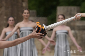 Grécka herečka Mary Minová (vpravo), ktorá stvárňuje úlohu veľkňažnej bohyne Héry v dobovej tunike, zapaľuje pochodeň počas slávnostného zapálenia ohňa pre XXXIII. olympijské hry v Paríži v antickej Olympii v utorok 16. apríla 2024.